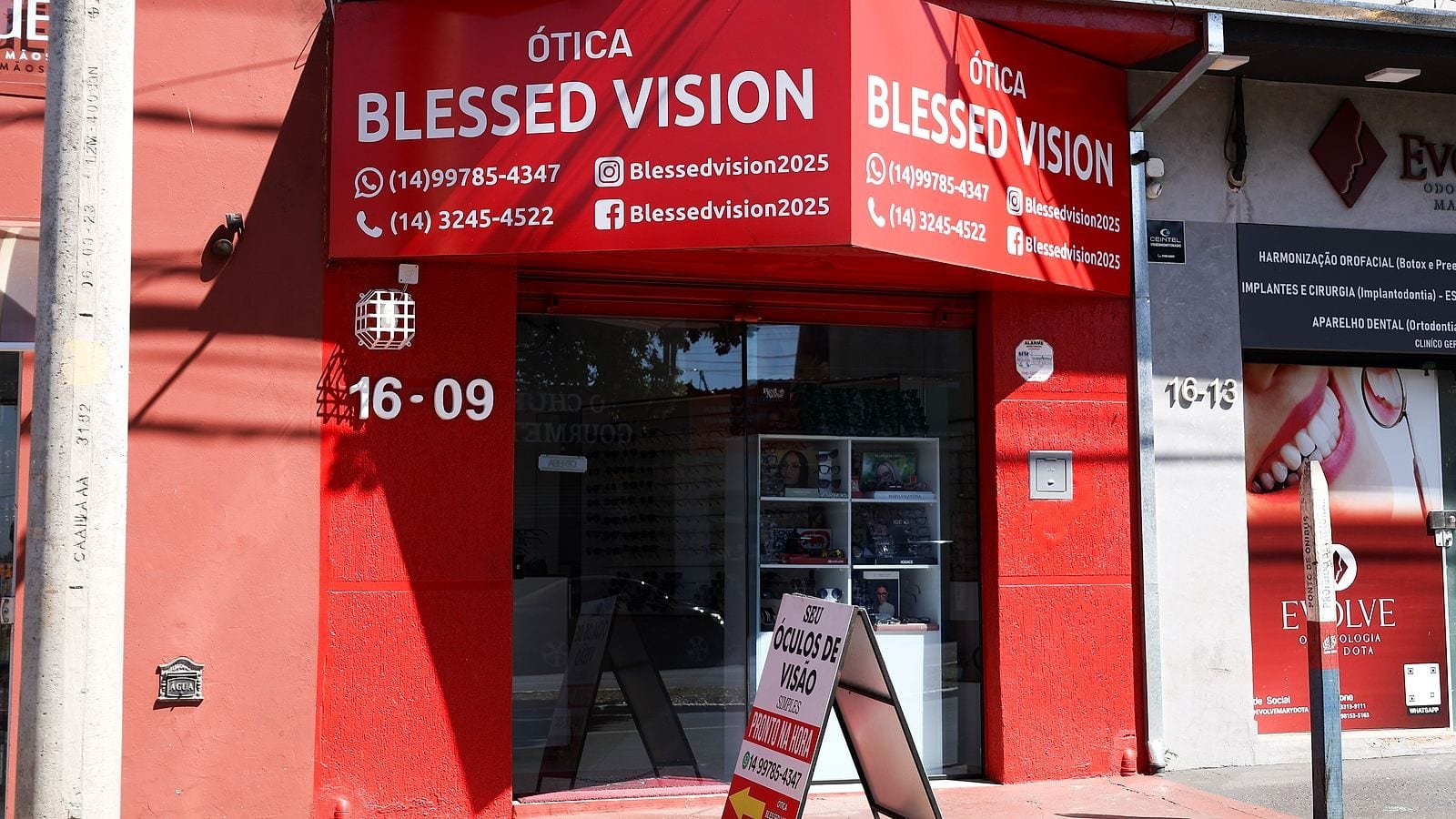 Fachada vermelha da Ótica Blessed Vision com o letreiro e o número 16-09, na Av. Dr. Marcos de Paula Rafael, bairro Mary Dota, Bauru